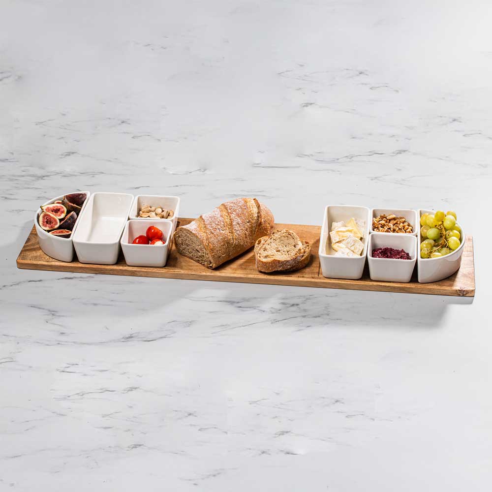 Servierplatte groß, gefüllt mit verschiedenen Snacks, platziert auf dem Akazienholz, auf einer Küchenarbeitsplatte.