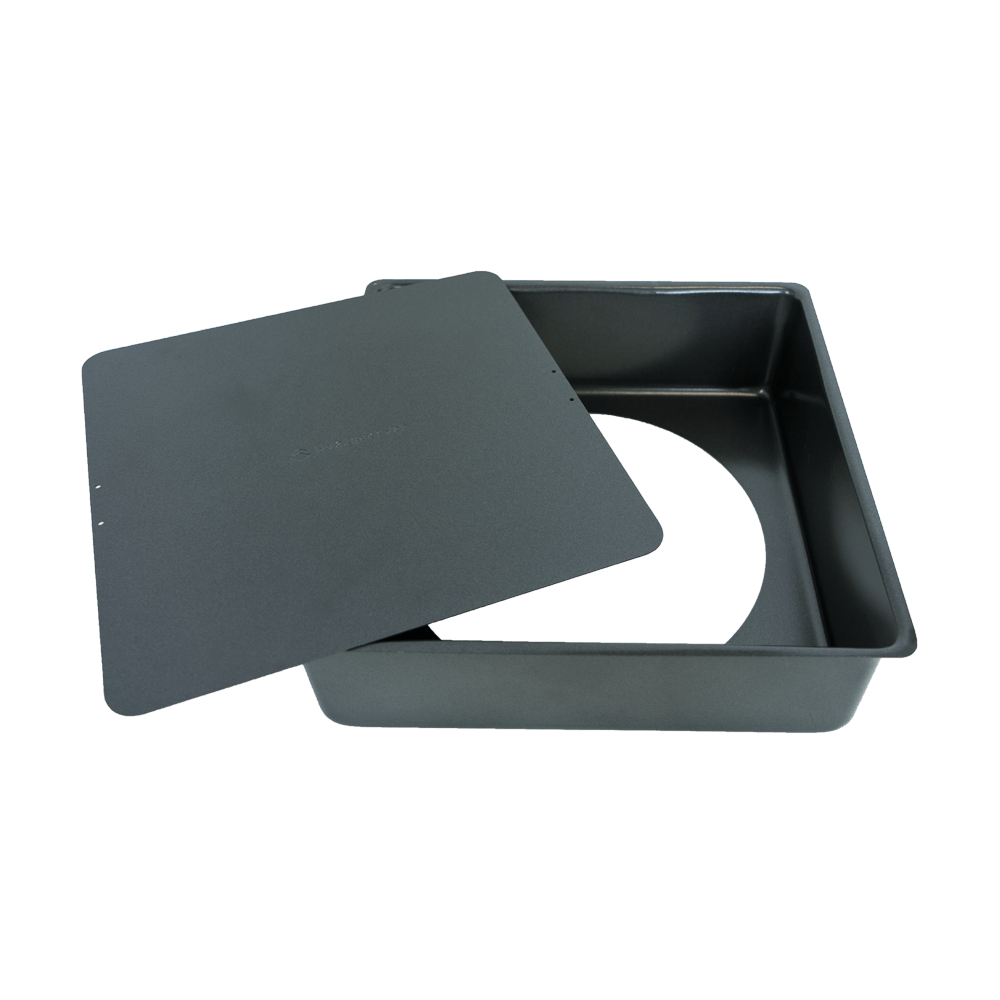 Kuchenform mit Hebeboden Kuchenform schwarz und quadratisch ohne Hintergrund. Der Hebeboden ist herausgenommen und liegt seitlich auf der Form.