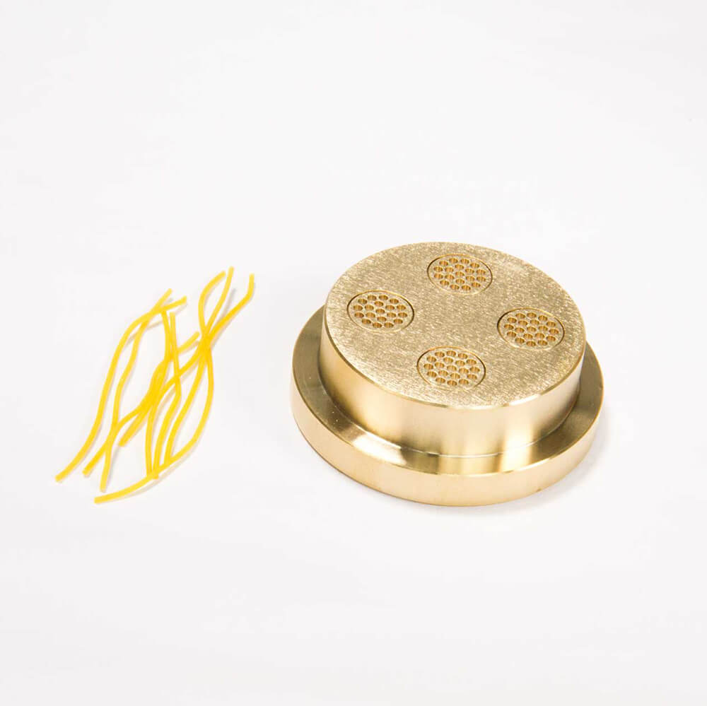 Matrize Nr. 1 - Capellini / Suppennudel Nudelmatrize Nr. 1 für Suppennudeln neben einigen Suppennudeln vor einem weißen Hintergrund.