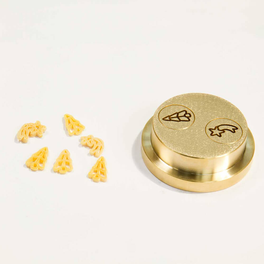 Matrize Nr. 501 - Weihnachten Nudelmatrize Nr. 501 für Weihnachts-Nudeln neben Baum- und Stern-Nudeln vor einem weißen Hintergrund.