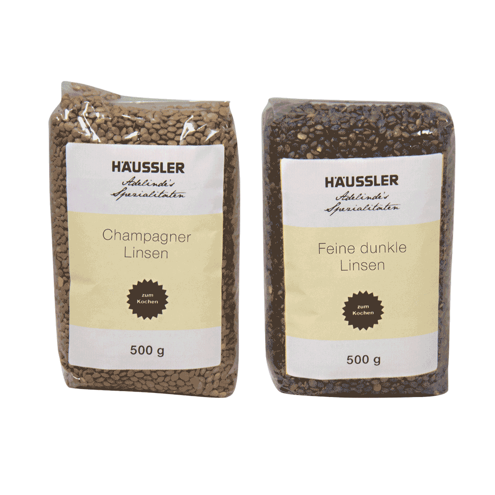 Champagner Linsen 500 g + Feine dunkle Linsen 500 g 2 Durchsichtige Verpackungen mit der Aufschrift Champagner Linsen 500 Gramm und Feine dunkle Linsen 500 Gramm