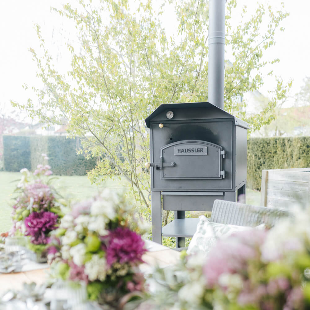 Holzbackofen in Profiqualität Holzbackofen im sommerlichen Garten mit sommerlichen Atmosphäre