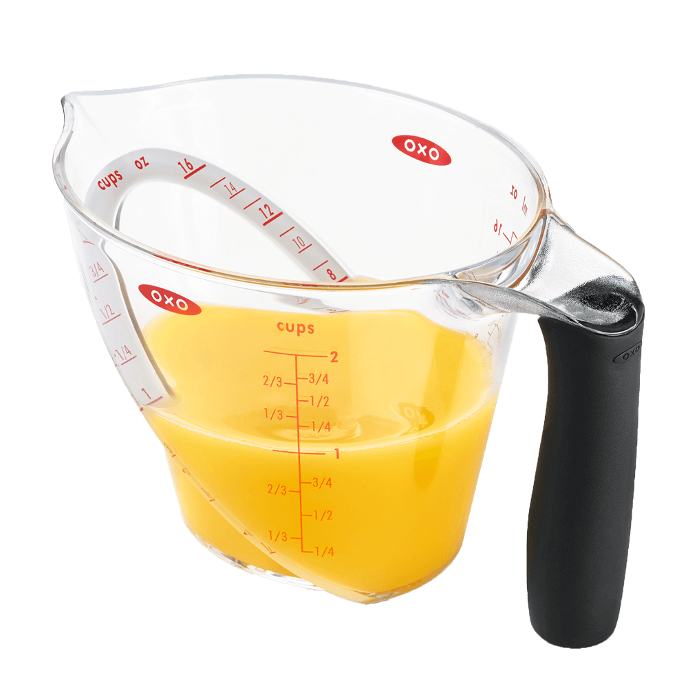 Messbecher mit abgewinkelter Skala Messbecher mit schwarzem Griff. Die Skala ist in roter Schrift aufgedruckt. Der Messbecher ist gefüllt mit gelber Flüssigkeit