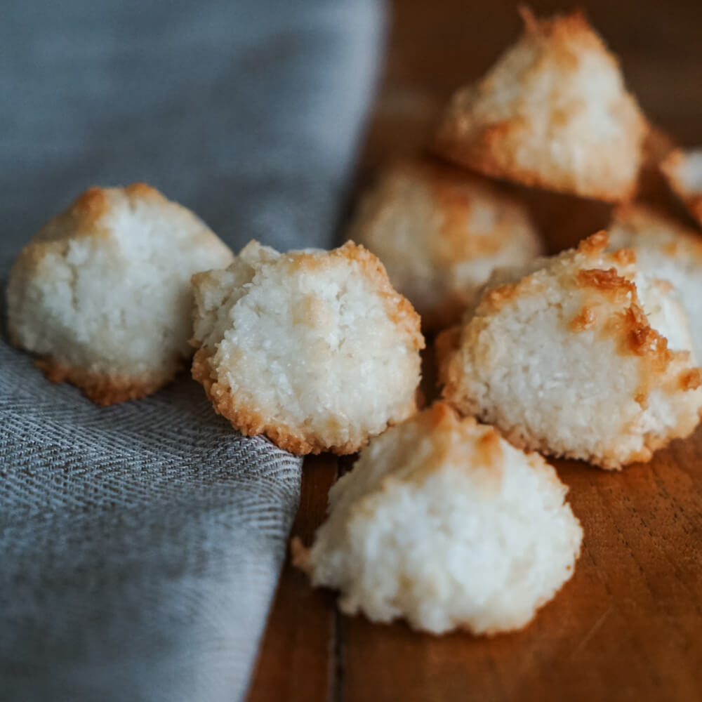 Rezept für Kokosmakronen leicht gebräunte Kokosmakronen auf einem grauen Tuch