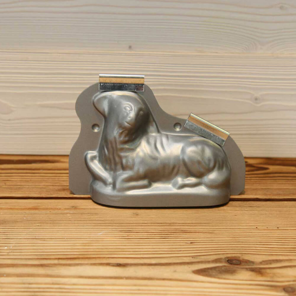 Lammbackform Die Lammbackform mit dem Osterlamm, dass zur Seite schaut, steh auf einem braunen Tisch