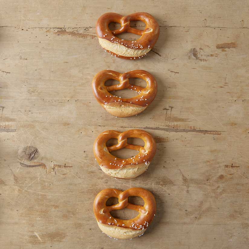 knusprige Brezeln Vier Brezeln auf einem Holzuntergrund
