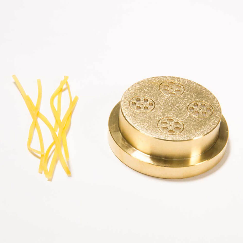 Nudelmatrize Nr. 17 für Schnittnudeln neben einigen Schnittnudeln vor einem weißen Hintergrund.