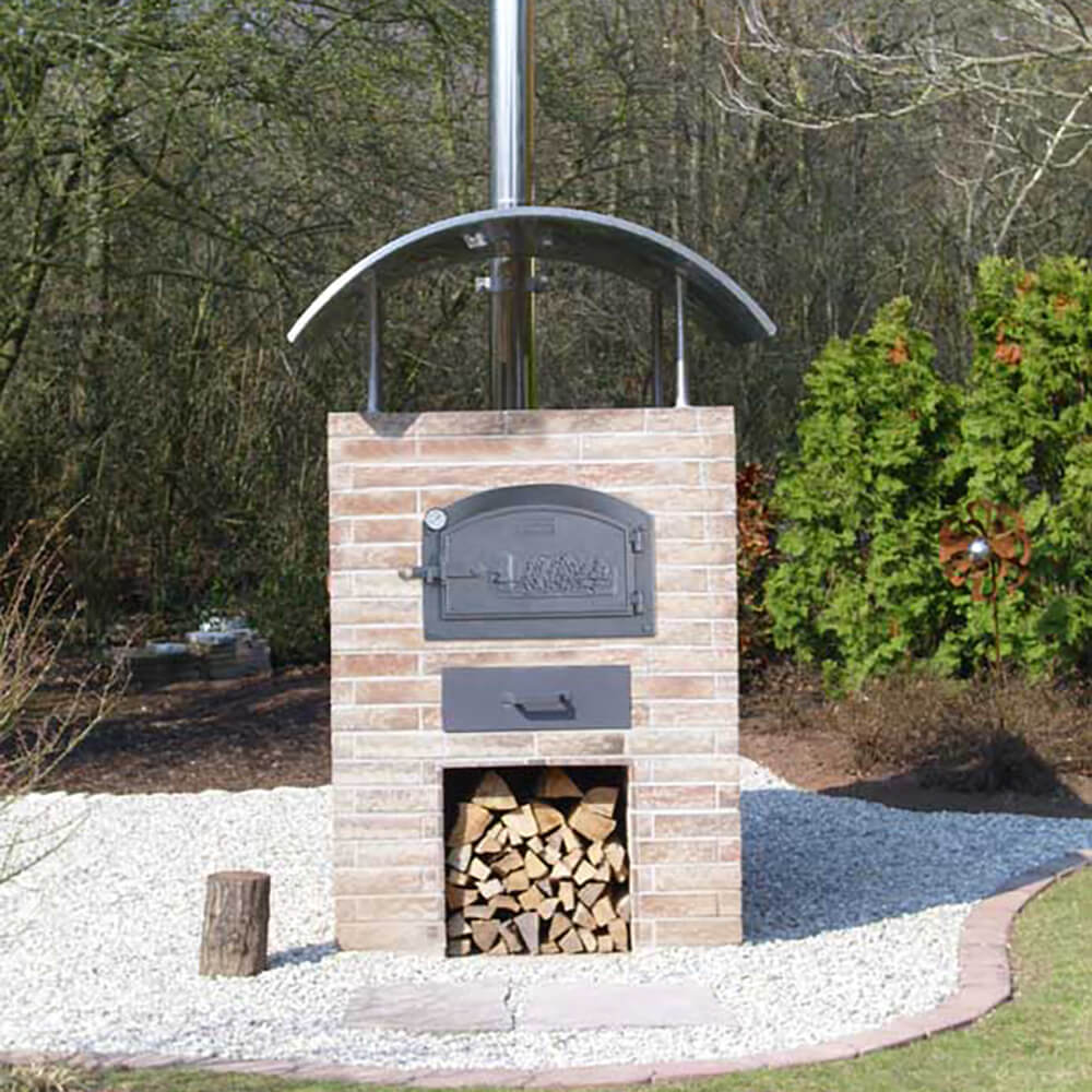 Aufgebauter HABO Bausatz zu einem schönen Backhäuschen aus Ziegel, mit einem runden Dach auf einer Kiesfläche.