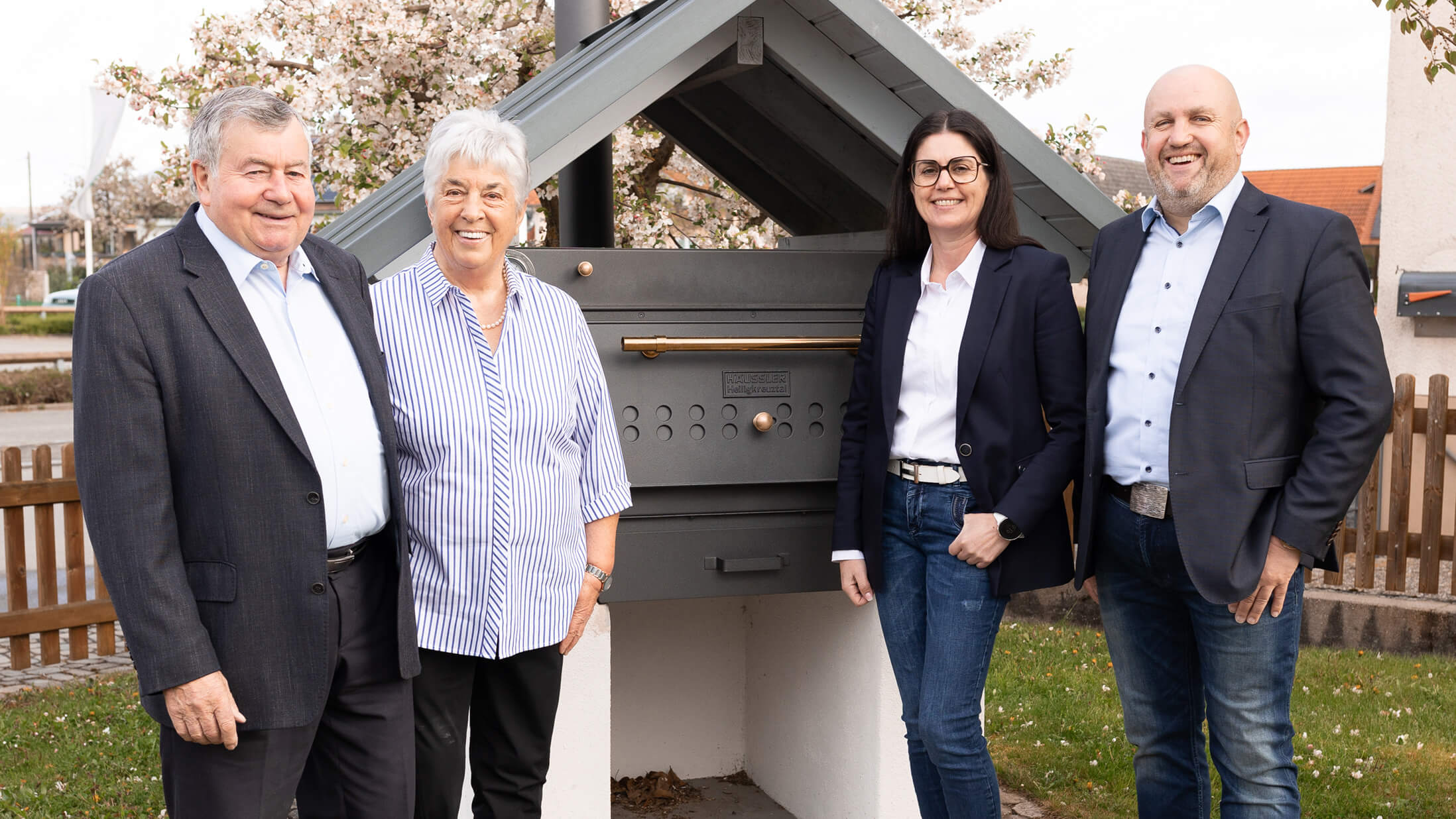 Familie Häussler steht vor einem traditionellen Holzbackofen.