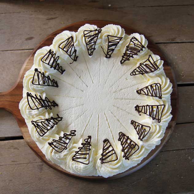 Tortenteiler Torte mit Sahne dekoriert und Druckstellen eines Tortenteilers.