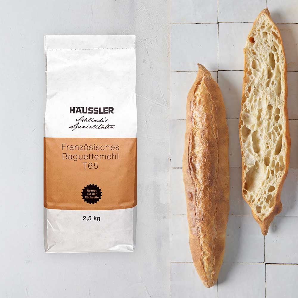 Französisches Baguettemehl T65 von Häussler mit frisch gebackenem Baguette Packung französisches Baguettemehl T65 von Häussler (2,5 kg) neben einer aufgeschnittenen knusprigen Baguettehälfte