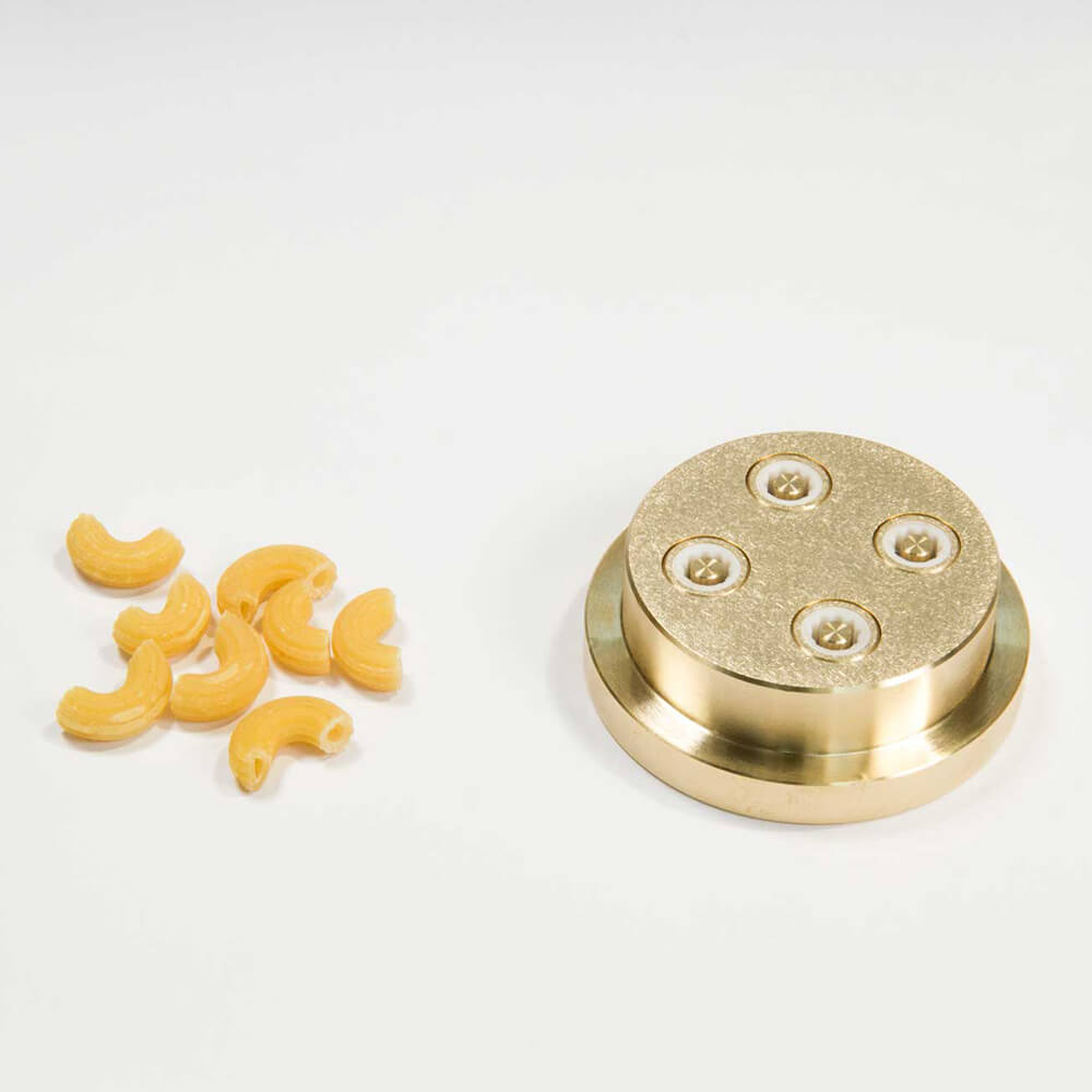 Nudelmatrize Nr. 36 für Hörnlenudeln neben einigen Hörnle-Nudeln vor einem weißen Hintergrund