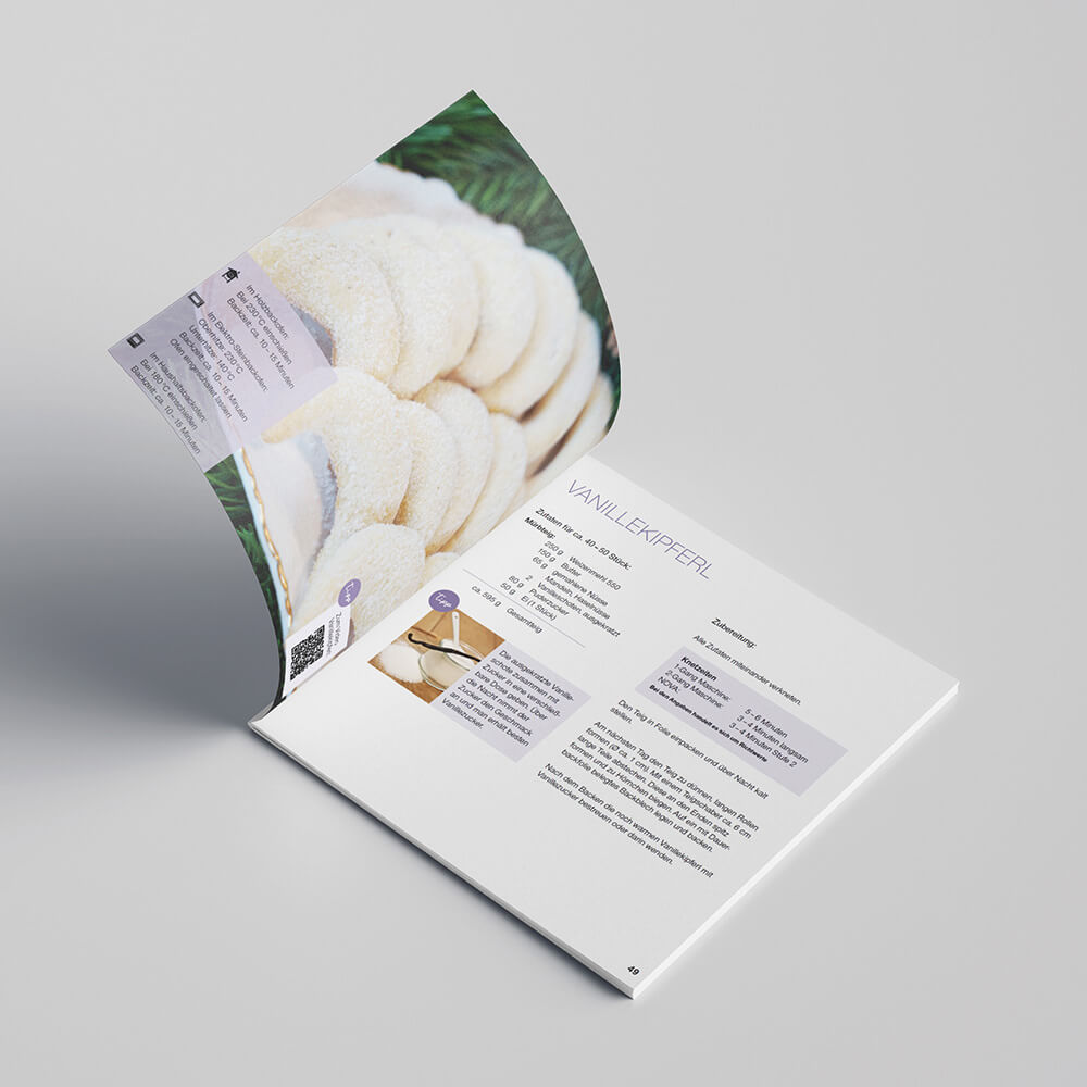 Häussler-Buch: Weihnachtsbäckerei. Das Buch liegt aufgeschlagen auf einem weißen Tisch