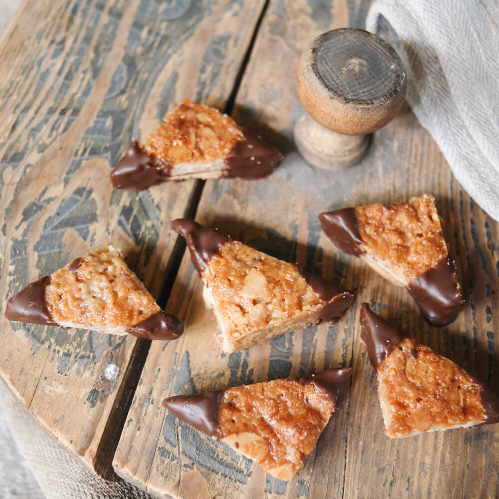 Rezept für Nussecken Nussecken mit Schokoglasur auf einem Holzbrett serviert