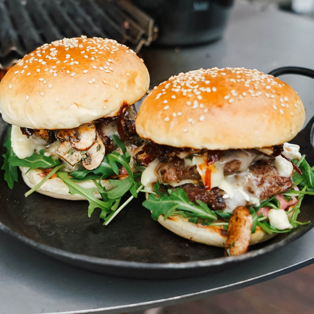 Rezept für Wildburger Zwei Wildburger auf einem dunklen Teller