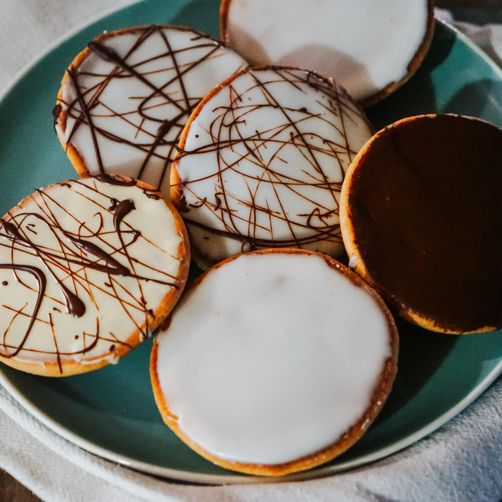 Rezept für Amerikaner Amerikaner mit weißer, dunkler und gemischter Glasur auf einem grünen Teller serviert