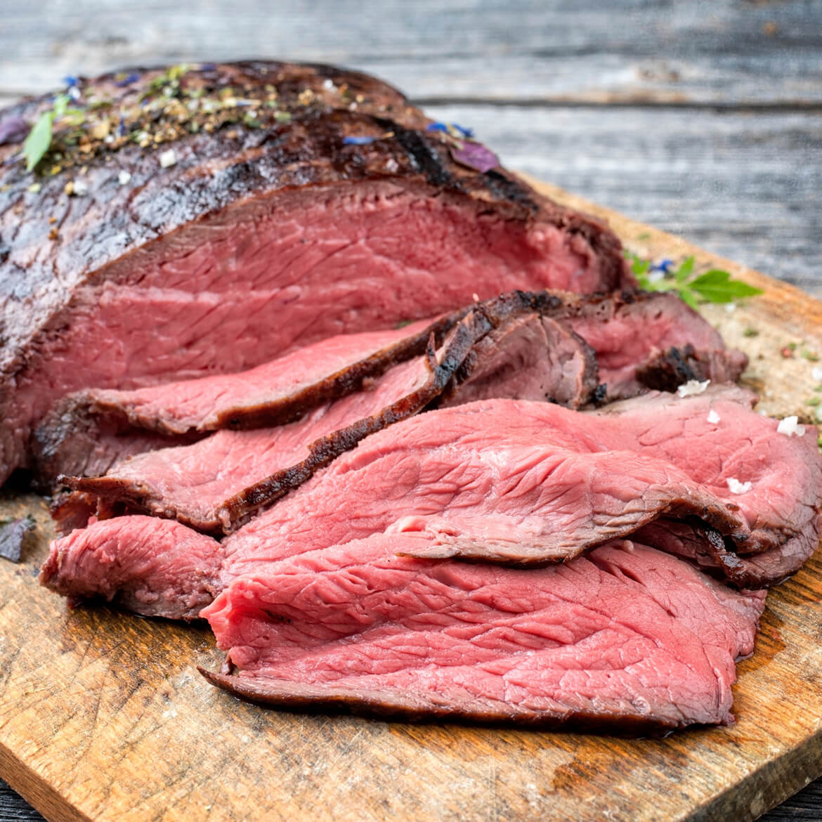 perfekt gegartes Roastbeef Roastbeef aufgeschnitten in den dünnen Scheiben aif einem Schneidebrett