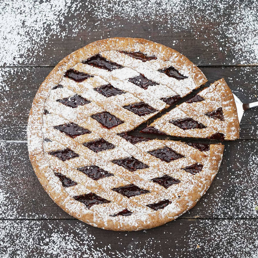 Linzertorte mit Puderzucker bestaubt und einem Kuchenheber