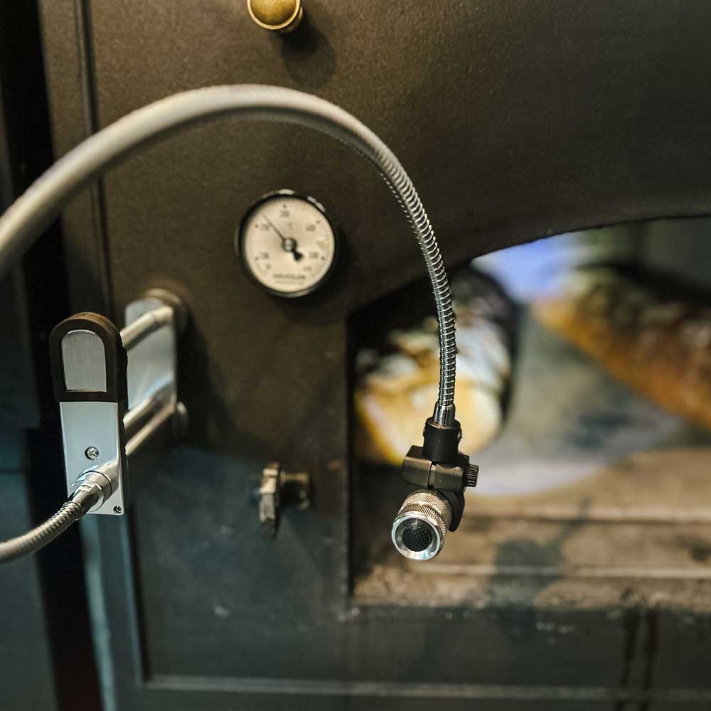 Grill- und Backofenleuchte mit Klemmhalterung Grillleuchte die über einen Magnet an einem Holzbackofen befestigt wird. Sie leuchtet in den Ofen Innenraum in dem gerade Brot gebacken wird.