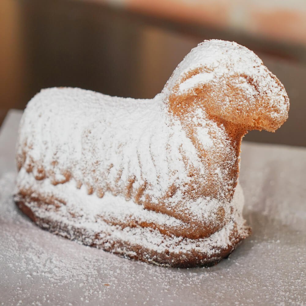 glutenfreies Osterlamm mit Puderzucker bestreut auf einem grauen Teller 