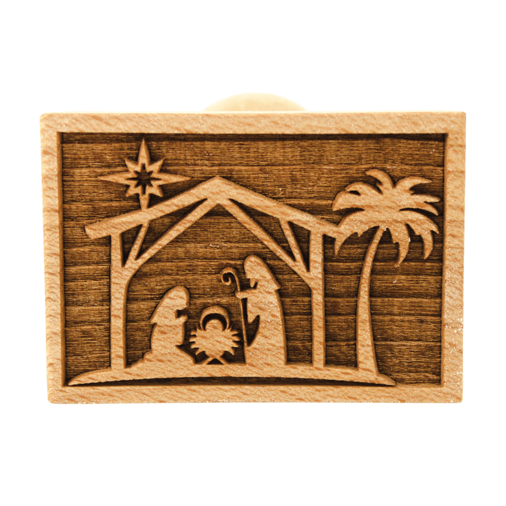 Keksstempel Druckkopf des Keksstempels. Es zeigt das weihnachtliche Motiv von Maria, Josef und dem Jesuskind in der Krippe in einem Stall. Über dem Stall ist ein Stern und rechts neben dem Stall steht eine Palme.