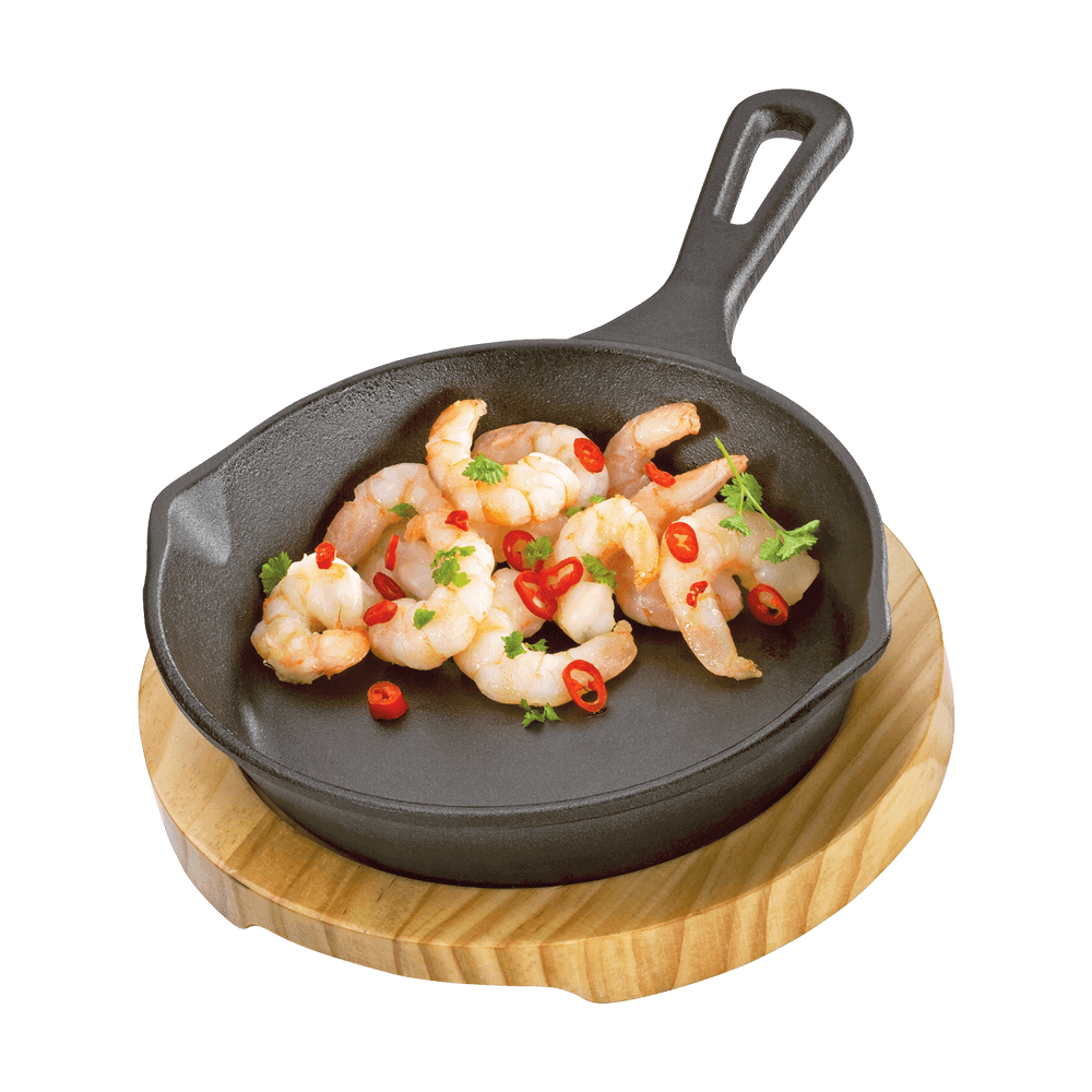 Runde Grillpfanne aus Gusseisen auf einem Holzbrett mit Gemüse und Fleisch, ohne Hintergrund.