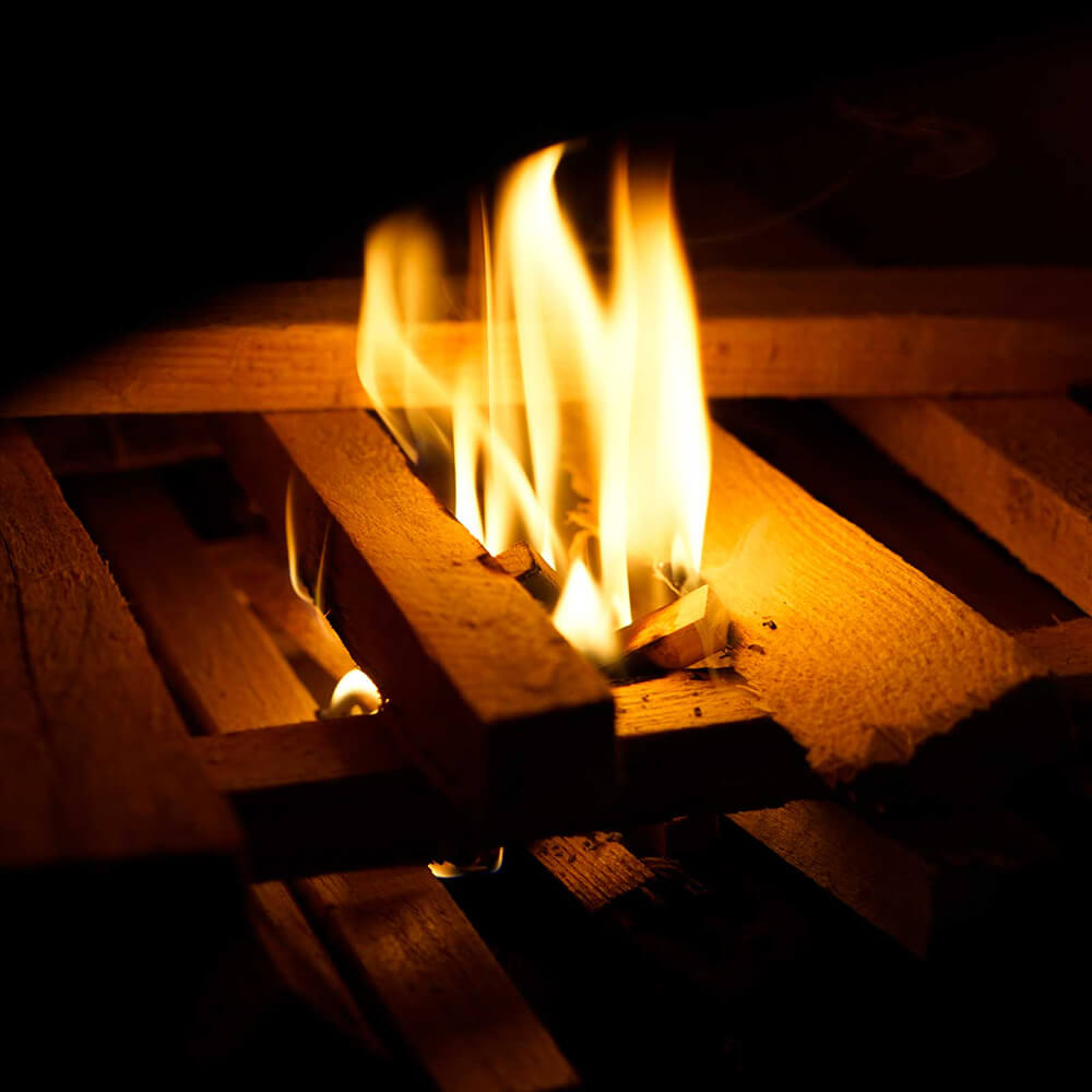 Petromax Feuerkit Gestapeltes Holz im Holzbackofen brennt