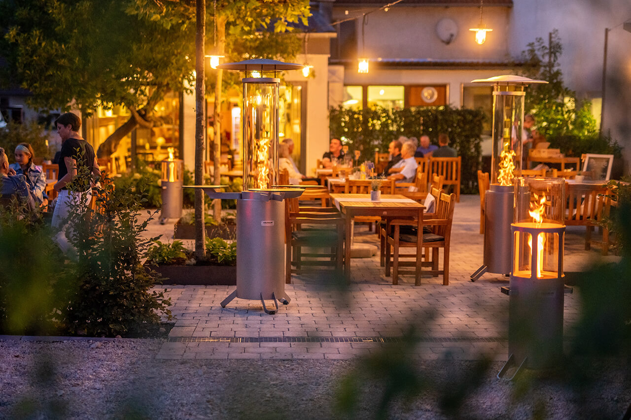 Stimmungsvoll beleuchtete Terrasse in der Dämmerung mit warmem Ambientelicht, gemütlicher Sitzgruppe und dekorativen Lichtquellen wie Laternen und Lichterketten.