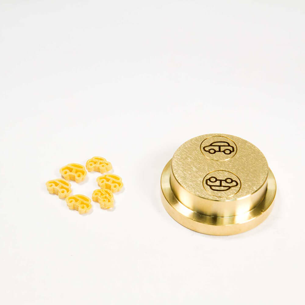 Nudelmatrize Nr. 530 für Auto-Nudeln neben einigen Auto-Nudeln vor einem weißen Hintergrund.