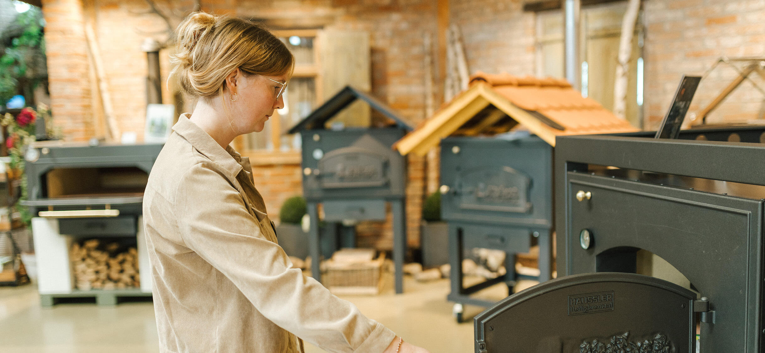 Besucherin schaut im Backdorfg in einen traditionellen Holzbackofen