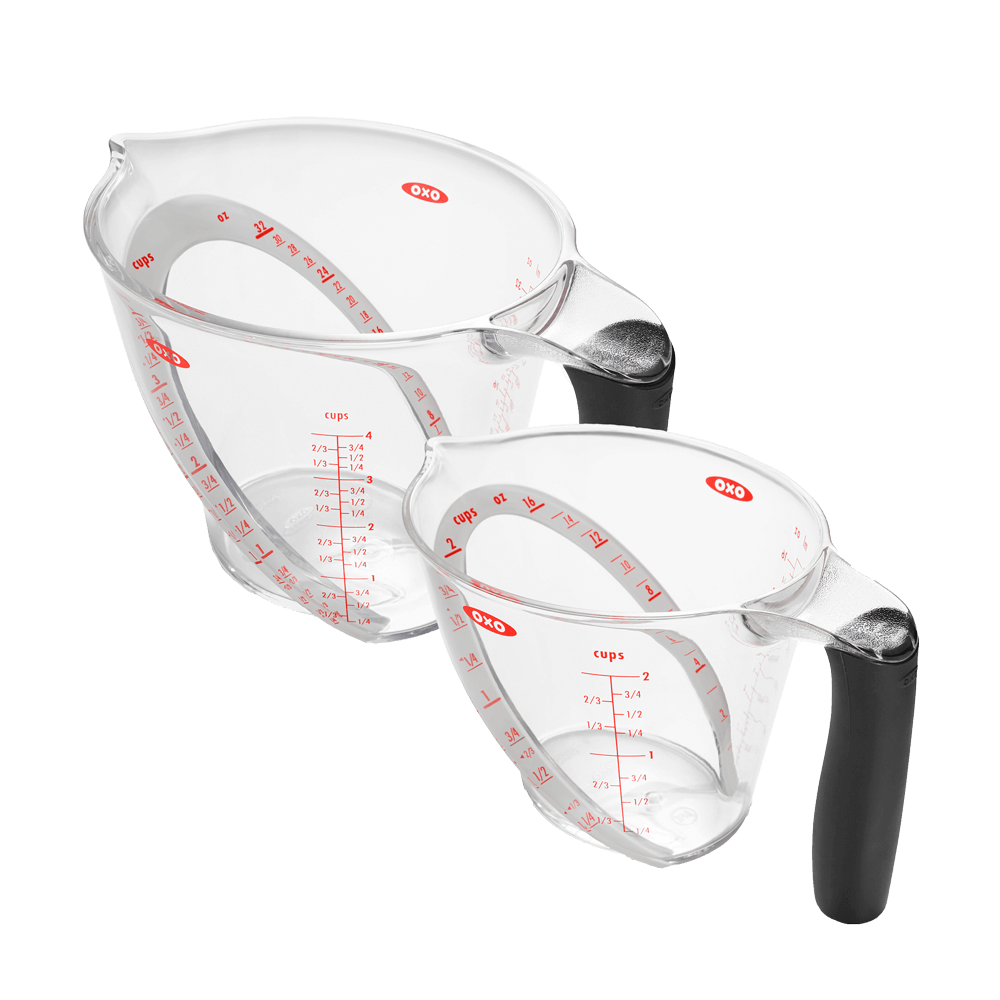 Messbecher mit abgewinkelter Skala zwei Messbecher die nebeneinander stehen, ein großer und ein kleiner Messbecher mit schwarzem Griff. Die Skala ist in roter Schrift aufgedruckt