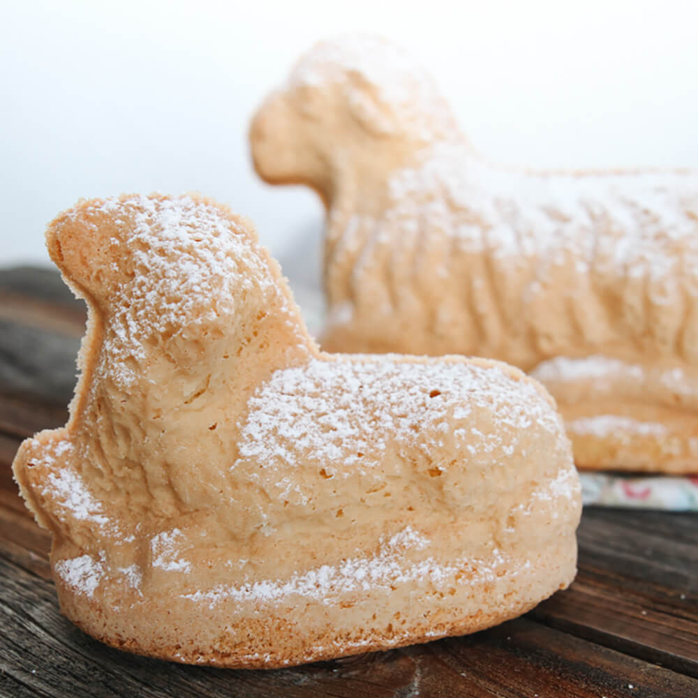 Luftige Osterlämmer Osterlämmer aus lockerem Biskuitteig, mit Puderzucker bestäubt - traditionelles Gebäck zu Ostern.
