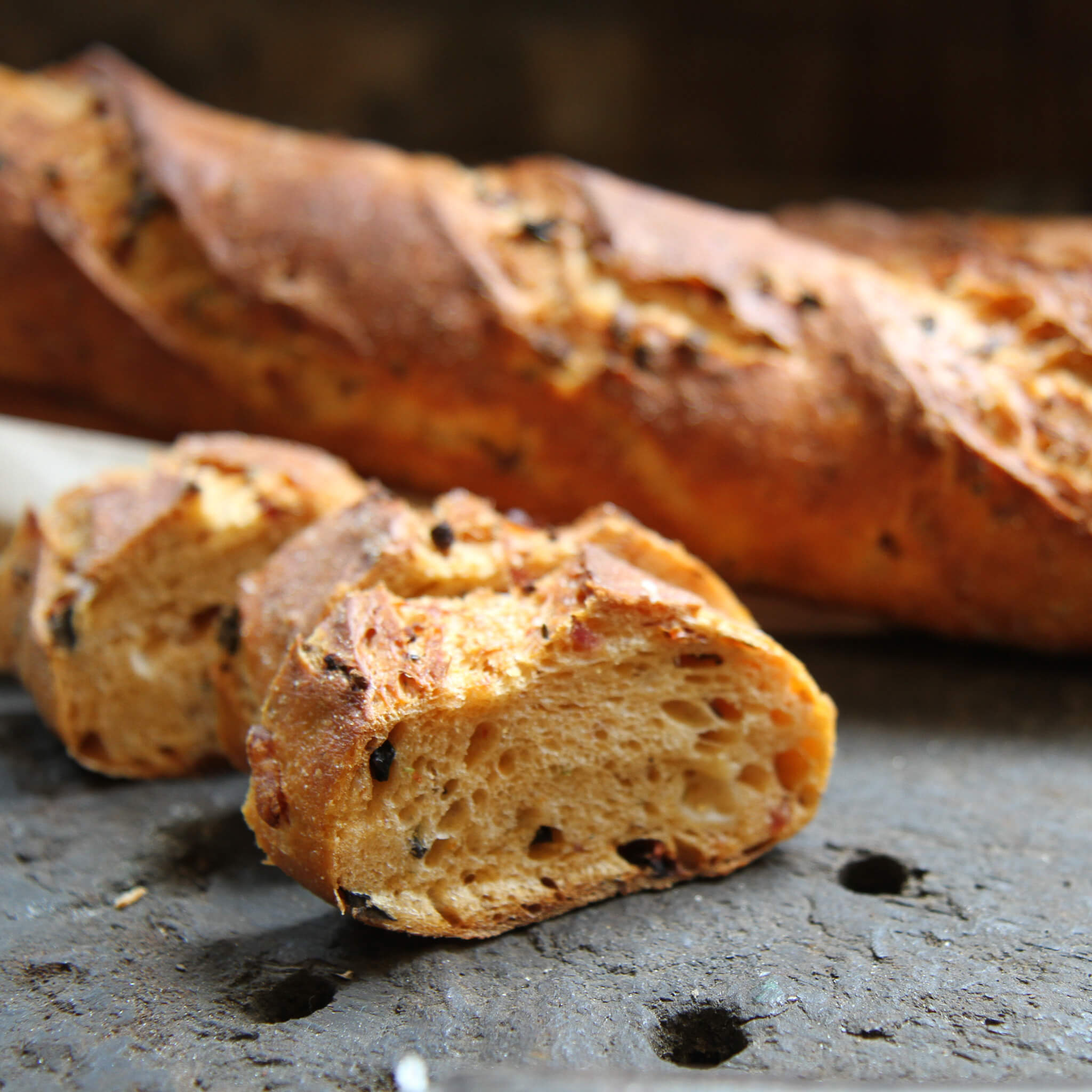 Rezept für Pizzastangen leckere Pizzastangen mit einer rötlichen Färbung durch die Tomatensoße und getrocknete Tomaten, Käse usw. im Teig