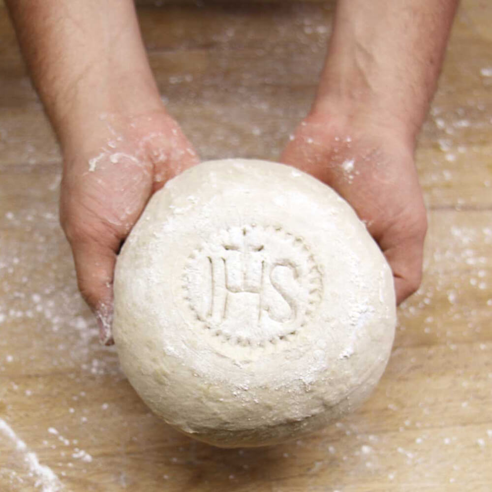 Brotstempel IHS rund geformter Brotteig mit Stempel IHS in der Mitte