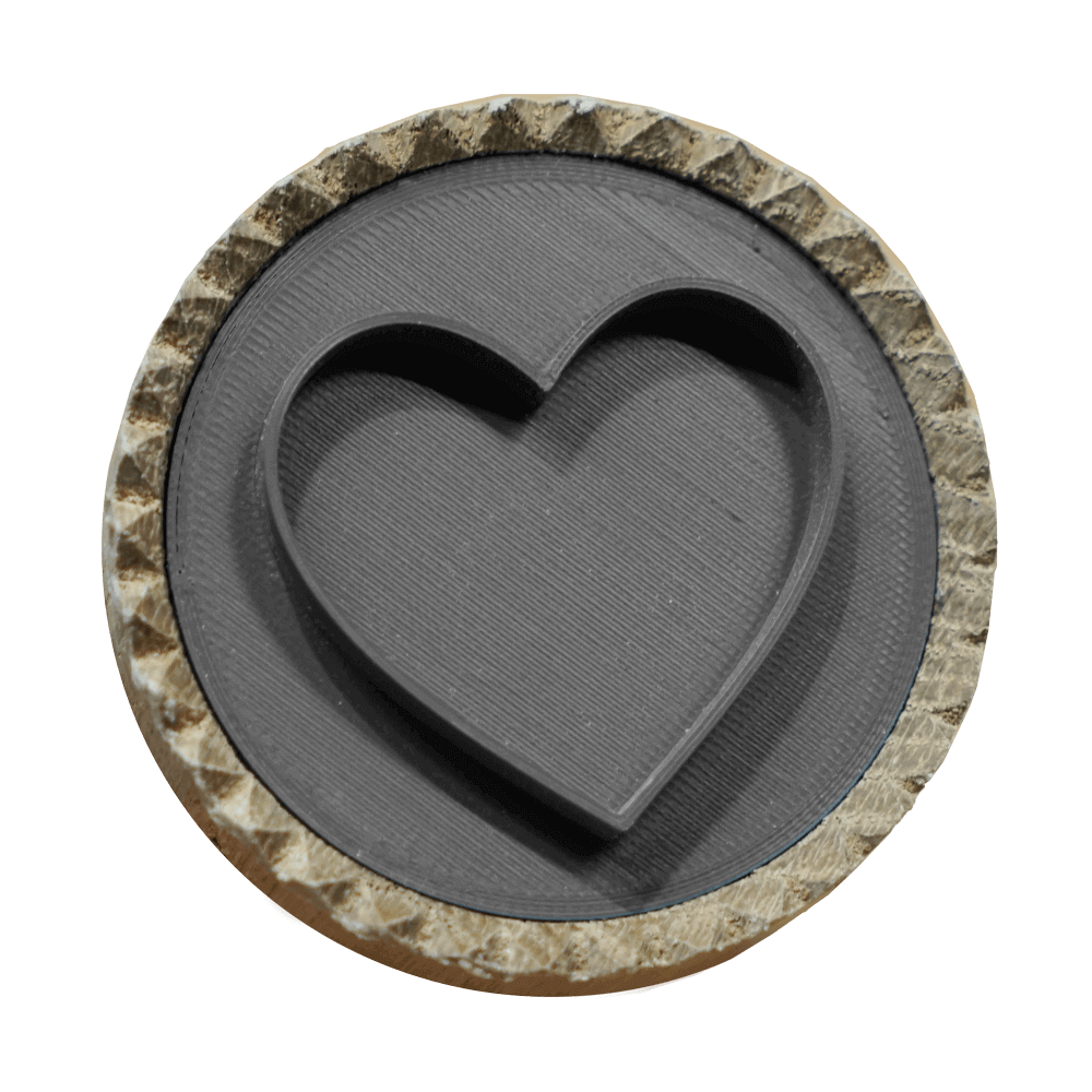 Brotstempel Herz Motiv Ein Brotstempel mit einem Herz-Motiv. Der Stempel ist aus hellem Holz und das Motiv aus grauem Kunststoff