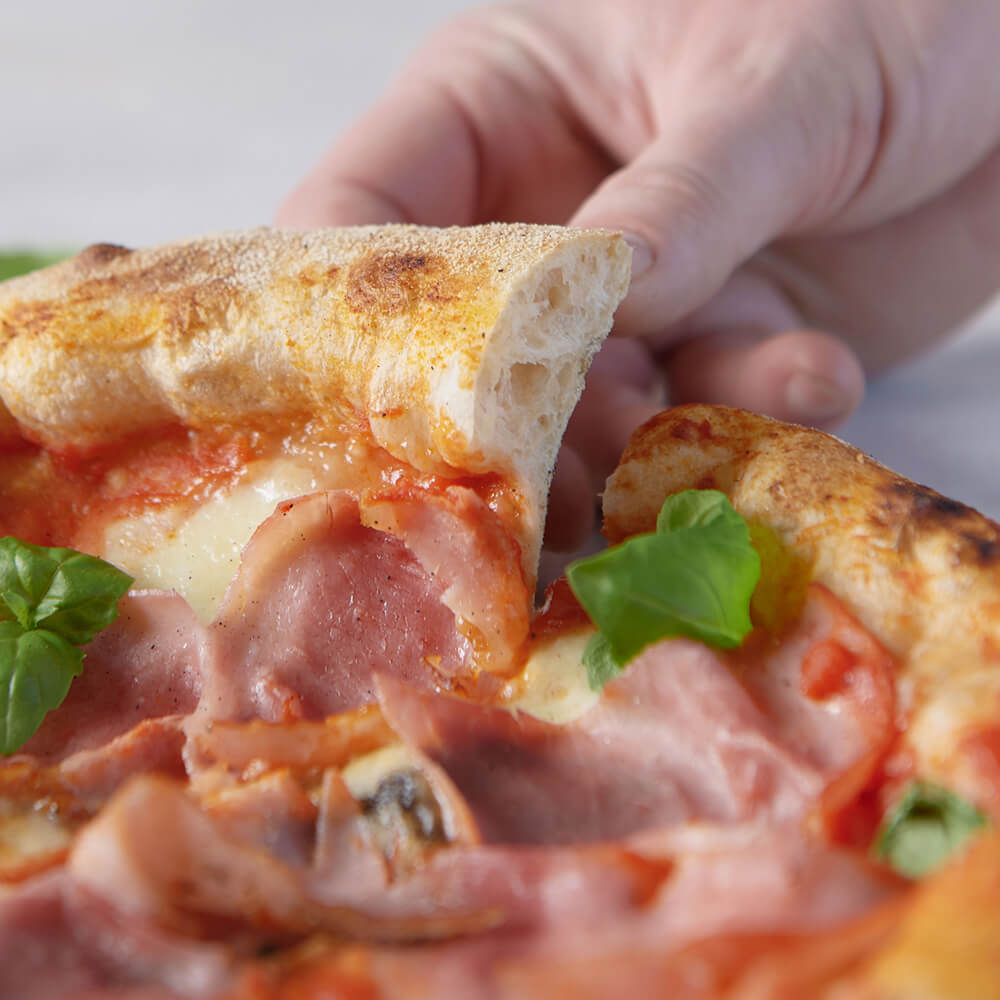 Luftige, krosse Pizza einfach mit dem Pizzamehl zuhause backen Detailaufnahme vom luftigen Pizzarand