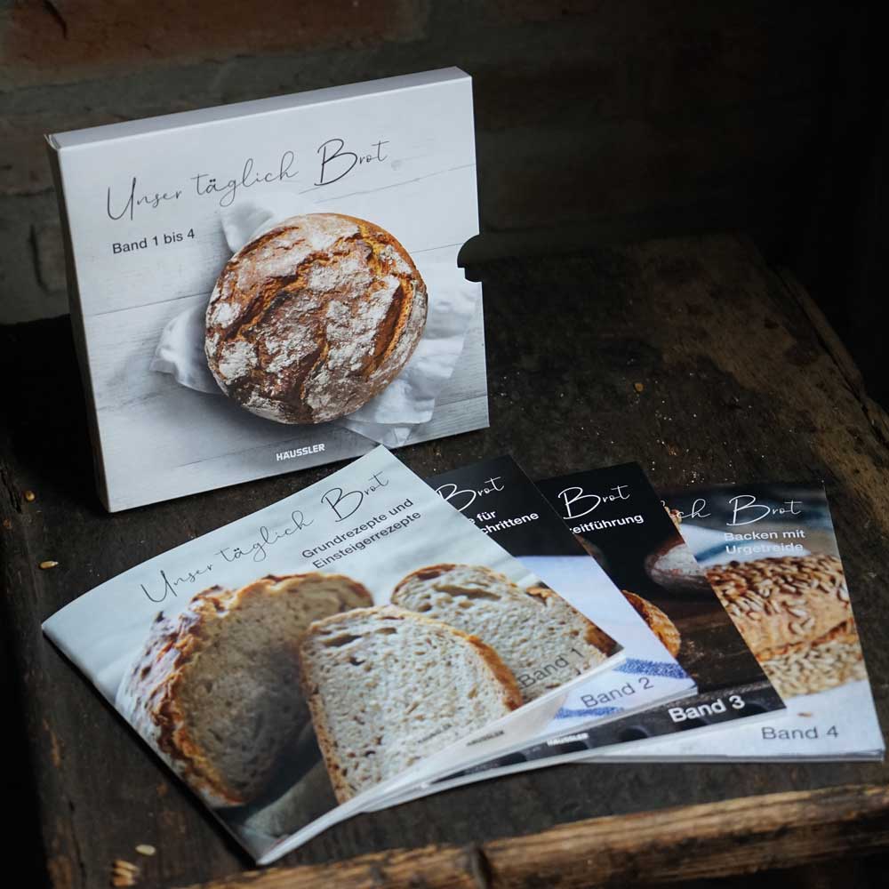 Backbuch-Set: Unser täglich Brot Band 1-4 Backbuch-Set mit allen 4 Büchern und daneben steht der Buchschuber
