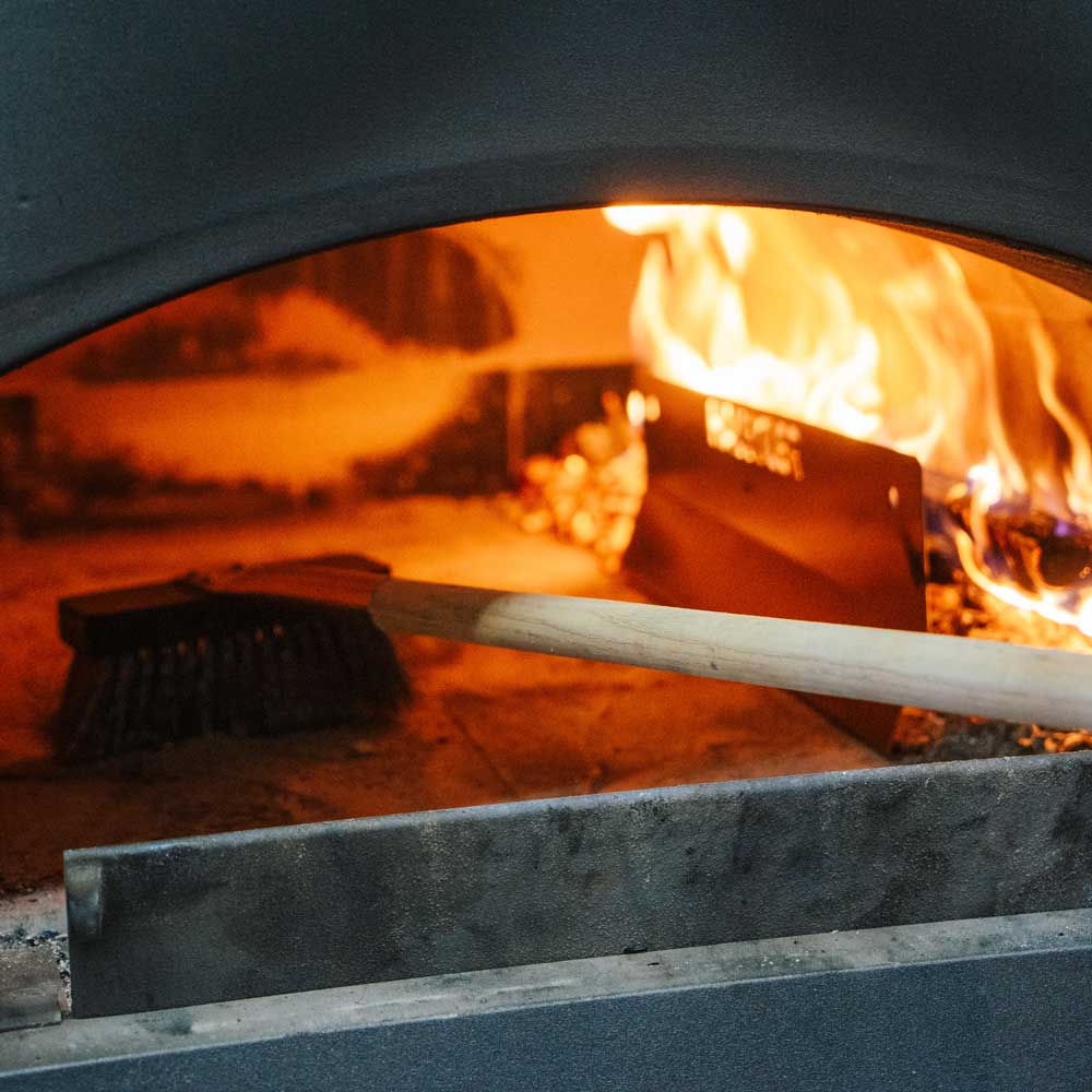 Prallblech für den Holzbackofen Prallblech und Glut im Ofen. Mit einer Aschekrücke wird der Ofen ausgekehrt