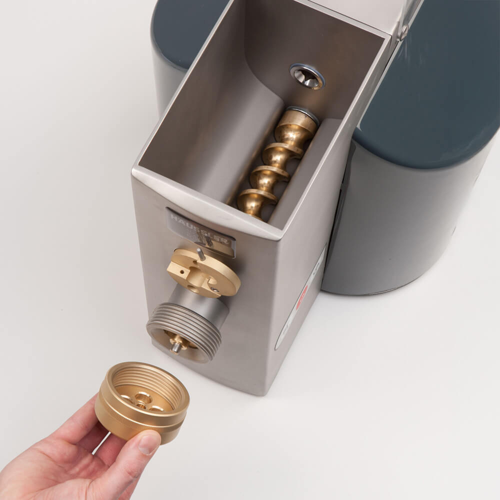 Bei der Nudelmaschine wird gerade die Überwurfmutter heruntergedreht.