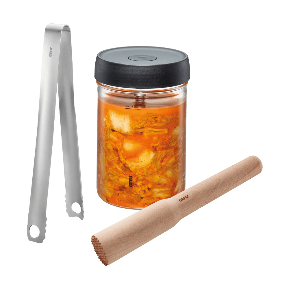 Fermentierset mit einem Glas, einem Stößel und einer Zange. Das Glas ist mit fermentiertem Gemüse gefüllt. Die Produkte sind ohne Hintergrund dargestellt.