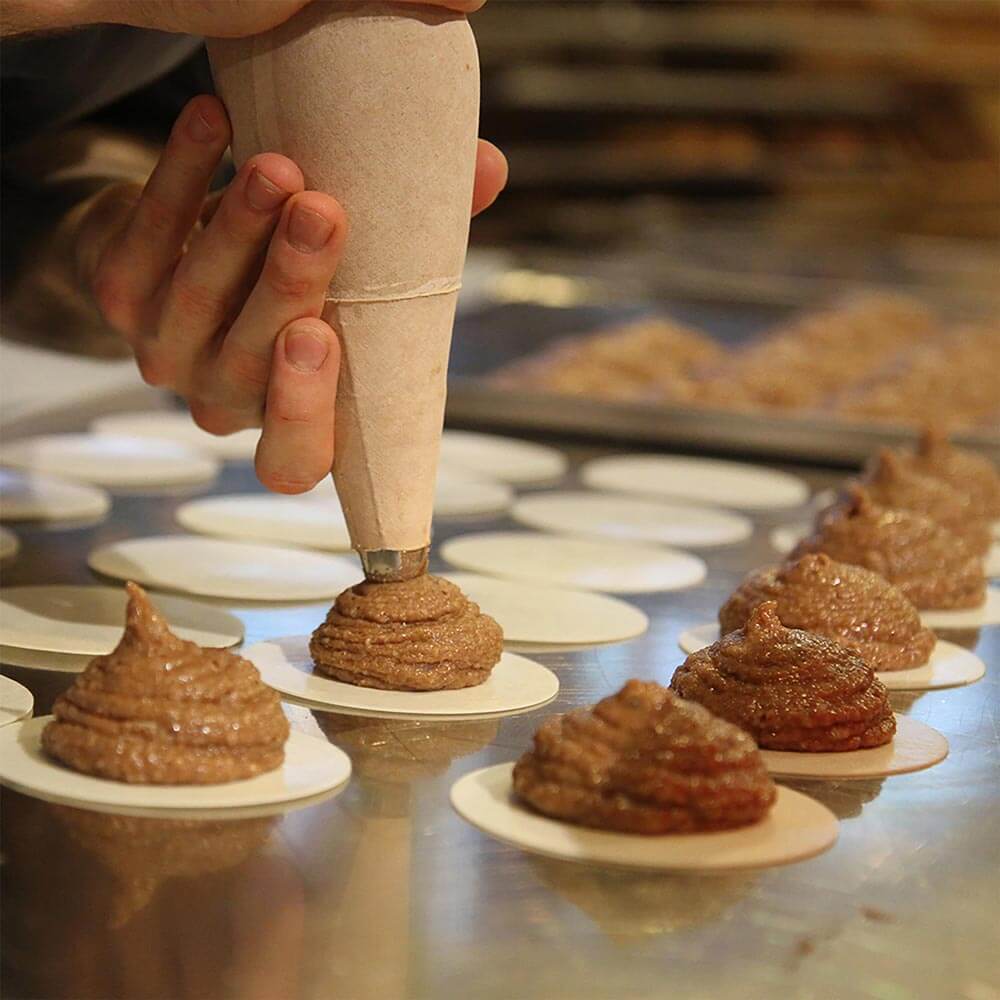 Spritzbeutel dressiert Lebkuchenteig auf Oblaten