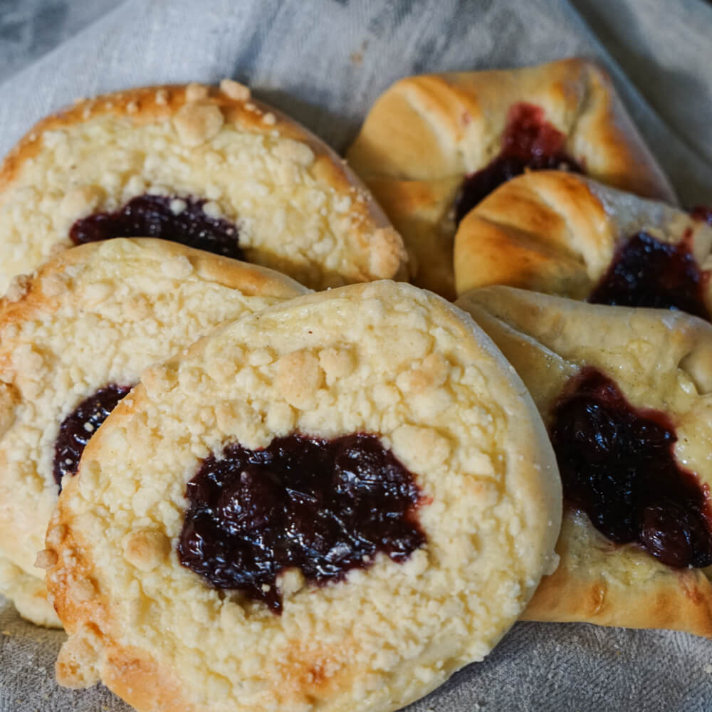 Rezept für Kirsch- / Apfelstreusel mehrer Selbstgemachte Streusel mit Apfel oder Kirschfüllung auf einem grauen Tuch