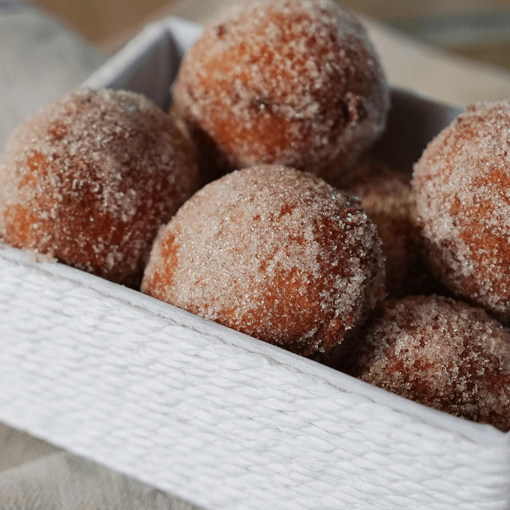 Rezept für Quarkbällchen mehrere Quarkbällchen die in einer Zimt-Zucker-Mischung gewälzt wurden in einer weißen Schüssel
