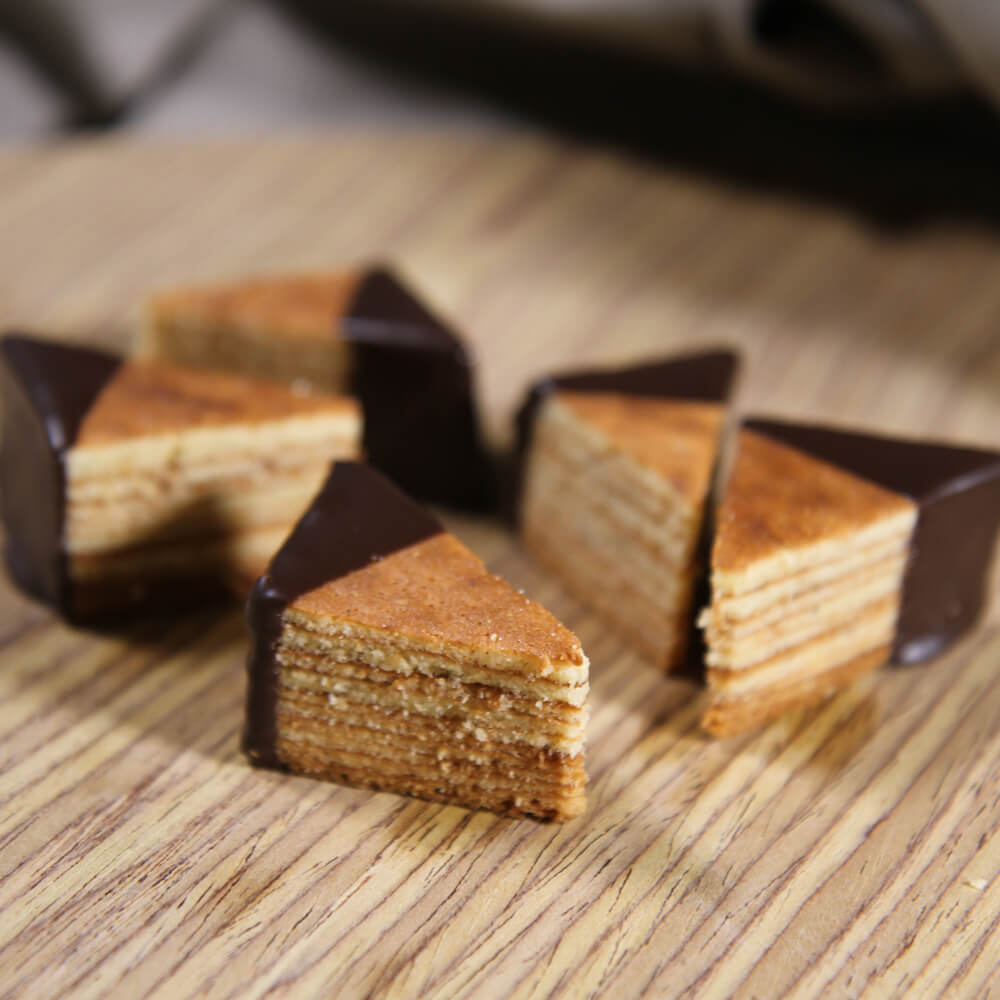 Rezept für Baumkuchen Baumkuchen in Dreiecke geschnitten und zur Hälfte mit einer Schokoglasur überzogen