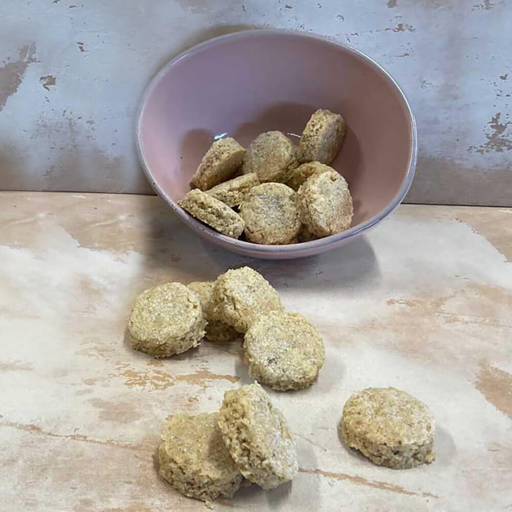 Backmischung Shortbread "Oats and Spelt" Shortbread "Oats an Spelt". Hintergrund: Grau-beige. Kekse liegen in einer rosefarbenen Schüssel und davor außerhal der Schüssel