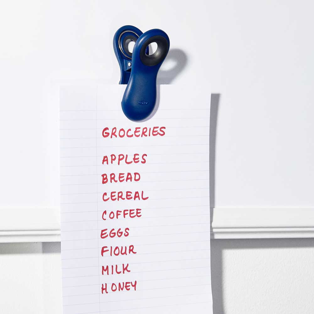 Verschlussklammern in blau hält die Einkaufsliste