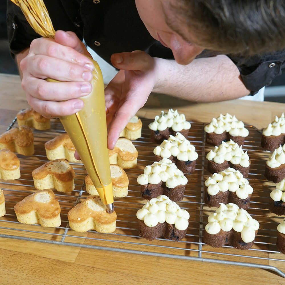 Einwegspritzbeutel verschönert Gebäck auf einem Rost