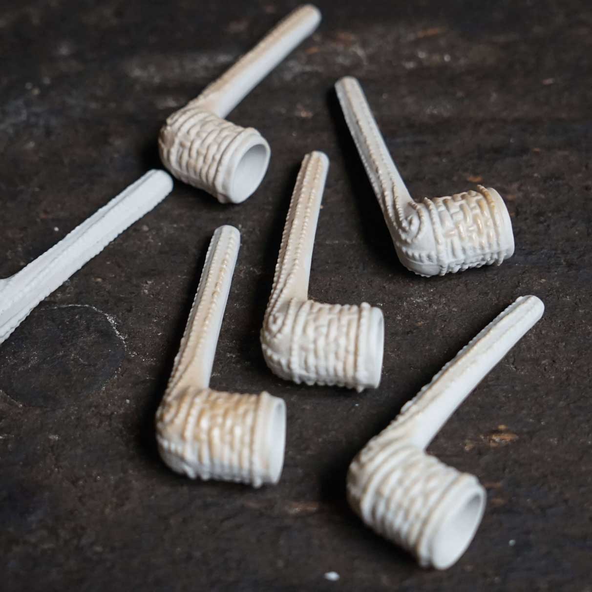 Nikolaus-Set Zubehör 6 Tonpfeifen auf einem schwarzen Tisch liegend