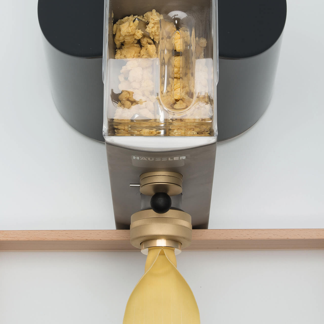 Teig wird durch Matrize gepresst Nudelmaschine presst Nudelteig durch Matrize