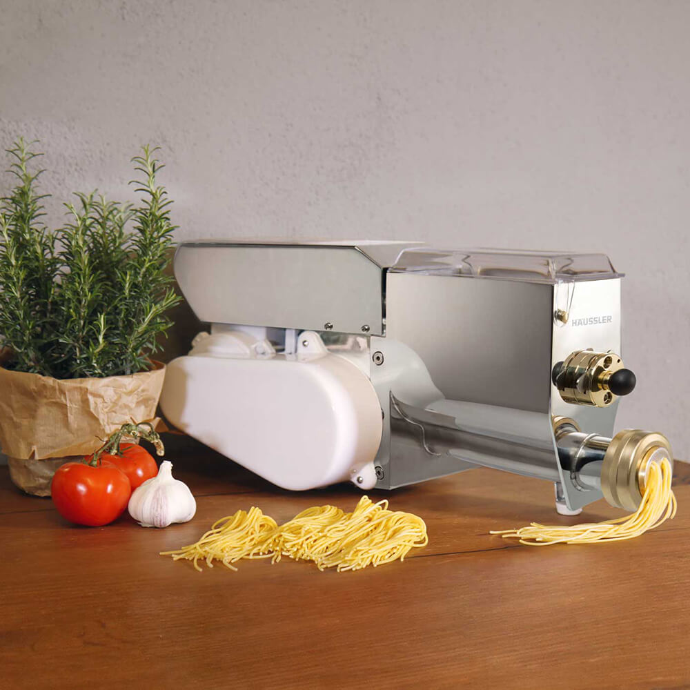 Nudelmaschine PN 100 Nudelmaschine aus Edelstahl die auf einer braunen Arbeitsfläche steht